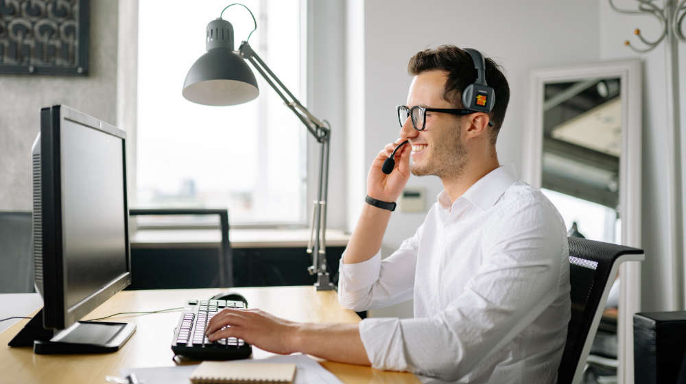 Geschäftsstelle Bürozeiten - Mann mit Headset und computer